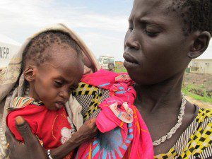 Mother brings child to the hospital tents